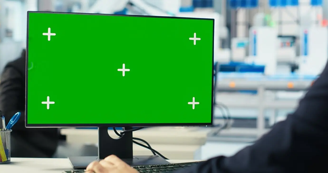 Arbeiter in einer Solarmodul-Fertigungsanlage, der mithilfe eines Green-Screen-PCs Ausfallzeiten reduziert.